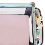 A pink fitted cot sheet in a cot with a whit ebackground