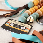 Colorful baby rattle with a cassette tape design label on a textured surface