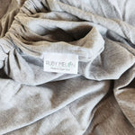 Close up of the grey marl knitted fabric for a baby camp cot mattress showing off the Ruby Melon stitch-in-tag.