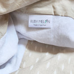 Ruby Melon Cover for Baby Change Mat with white feather pattern on natural beige