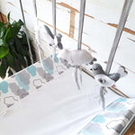 A set of four handcrafted dingle dangle toys in a meadow animal theme in grey and whit: a bunny, bird, lamb, and butterfly. Made from soft felt with ribbons, designed for infant sensory development.