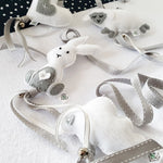 A set of four handcrafted dingle dangle toys in grey and white them: a bunny, heart, lamb, and cloud. Made from soft felt with ribbons, designed for infant sensory development.