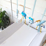 A set of four handcrafted dingle dangle toys in transport theme in blues: a train, hot air ballon, volksie, and plane. Made from soft felt with ribbons, designed for infant sensory development.