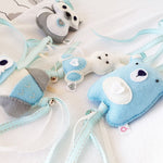 A set of four handcrafted dingle dangle toys in woodland animal shapes in shades of blue: a rabbit, an owl, a bear, and a deer. Made from soft felt with ribbons, designed for infant sensory development.