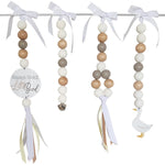 Decorative baby mobile with beads, ribbons, and a goose charm on a white background