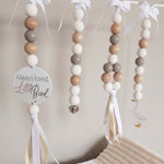 Decorative baby mobile with wooden beads and ribbons on a neutral background with goose theme