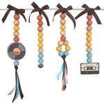 Decorative beads with ribbons and a tape and record player on a white background