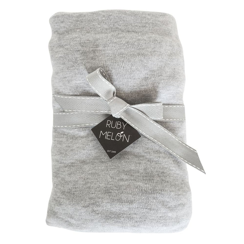 Image of a grey melange baby cot sheet rolled up and wrapped with grey ribbon on a pure white background
