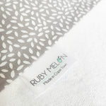 Ruby Melon Cover for Baby Change Mat with white leaf pattern on grey