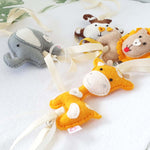 A set of four handcrafted dingle dangle toys in a multi-coloured safari theme: A lion, giraffe, elephant, and monkey. Made from soft felt with ribbons, designed for infant sensory development.