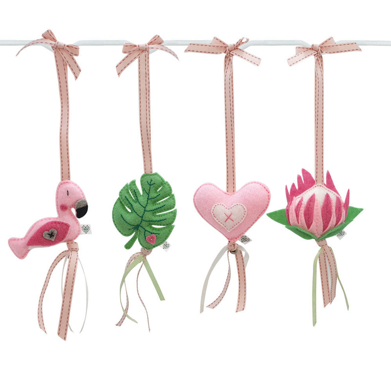 A set of four handcrafted dingle dangle toys in a flamingo theme in pinks and greens: a flamingo, leaf, heart, and protea. Made from soft felt with ribbons, designed for infant sensory development.