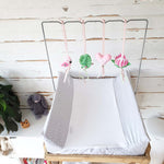 A set of four handcrafted dingle dangle toys in a flamingo theme in pinks and greens: a flamingo, leaf, heart, and protea. Made from soft felt with ribbons, designed for infant sensory development.