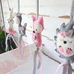 A set of four handcrafted dingle dangle toys in woodland animal shapes, made from soft felt with ribbons, designed for infant sensory development.