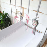 A set of four handcrafted dingle dangle toys in woodland animal shapes, made from soft felt with ribbons, designed for infant sensory development.